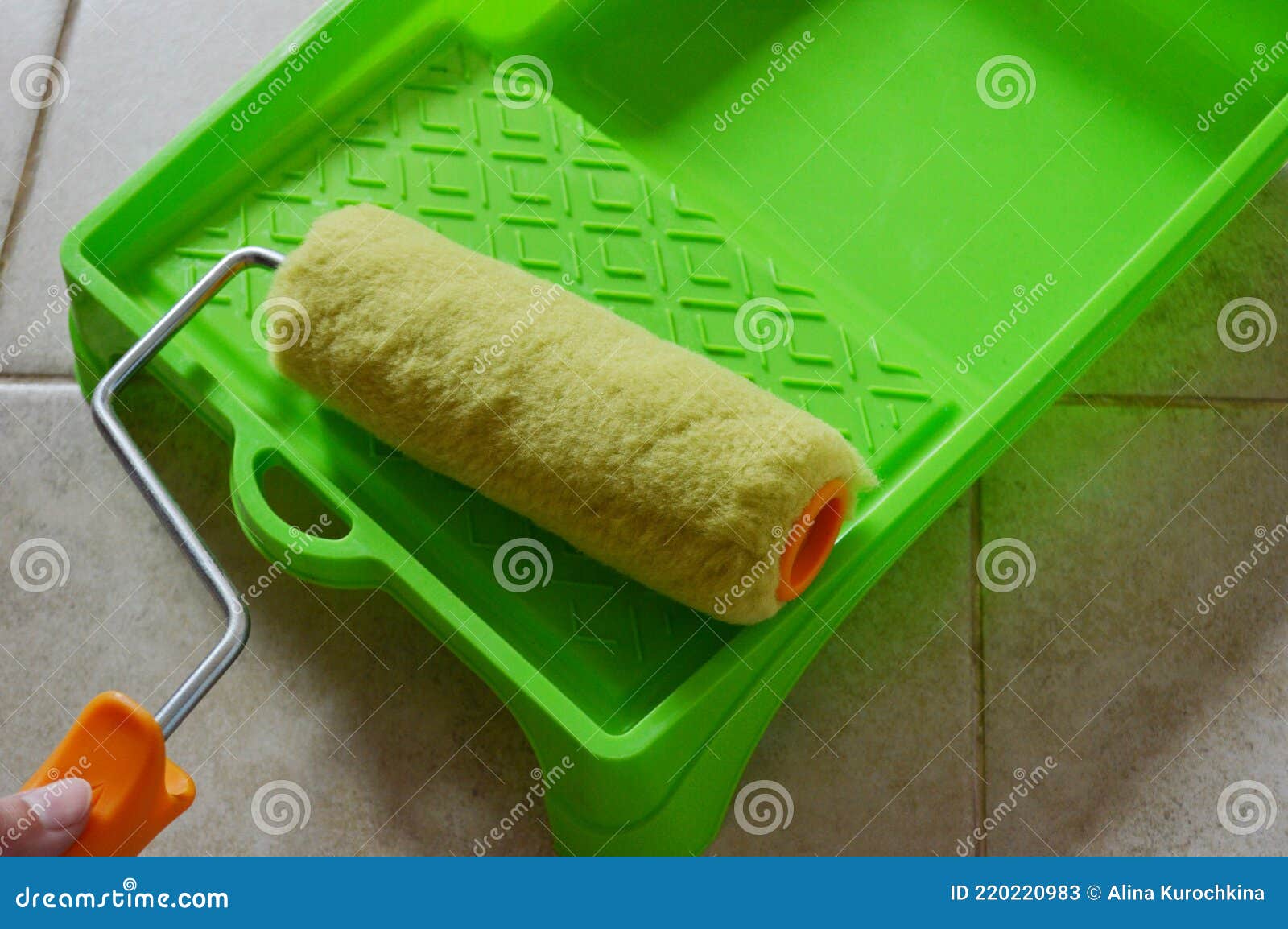 Paint Roller in Green Plastic Tray on Ceramic Tile Background Stock