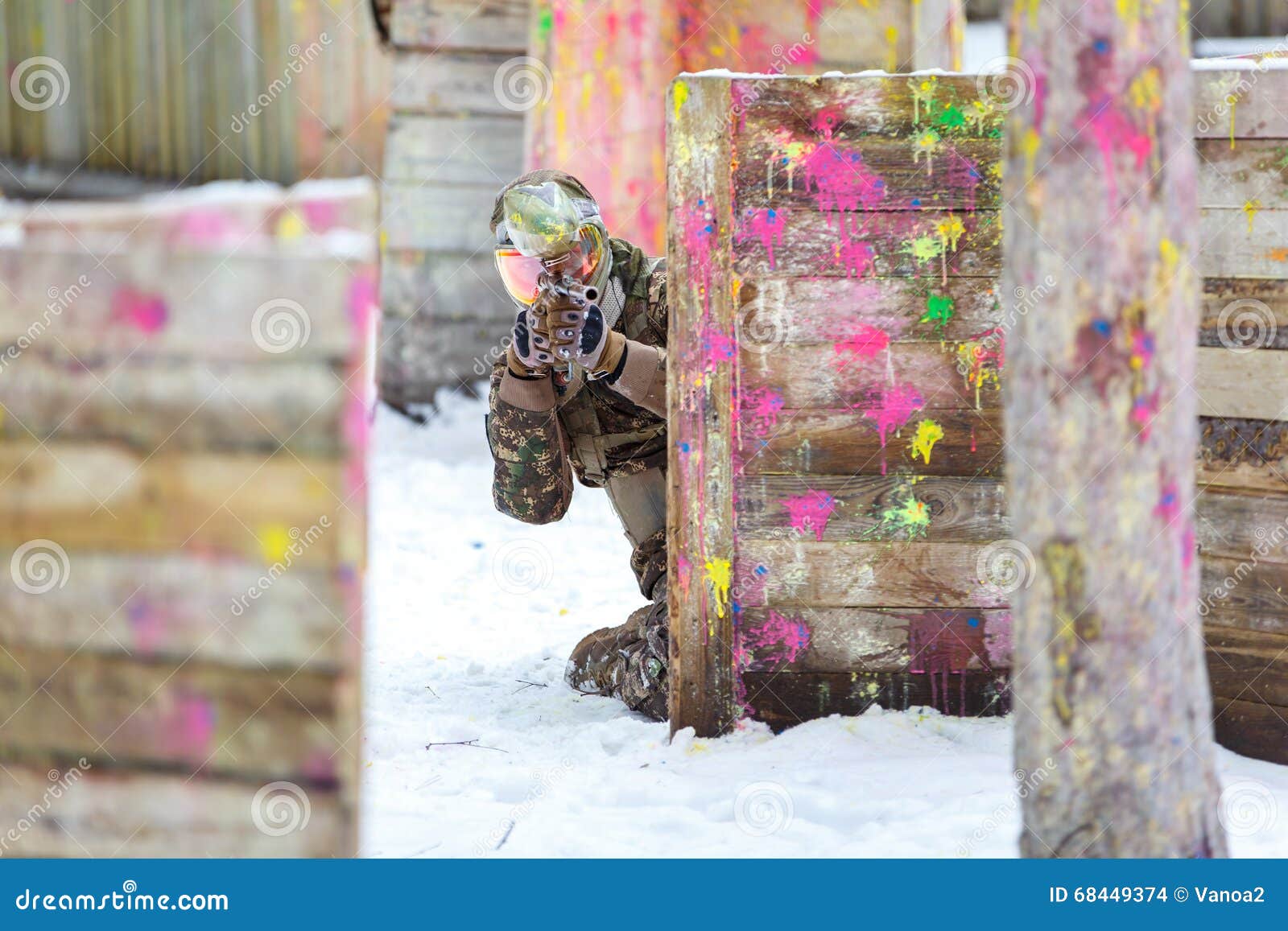 Paintball Game in Winter. Cool Shooter Behind Fortification. Stock
