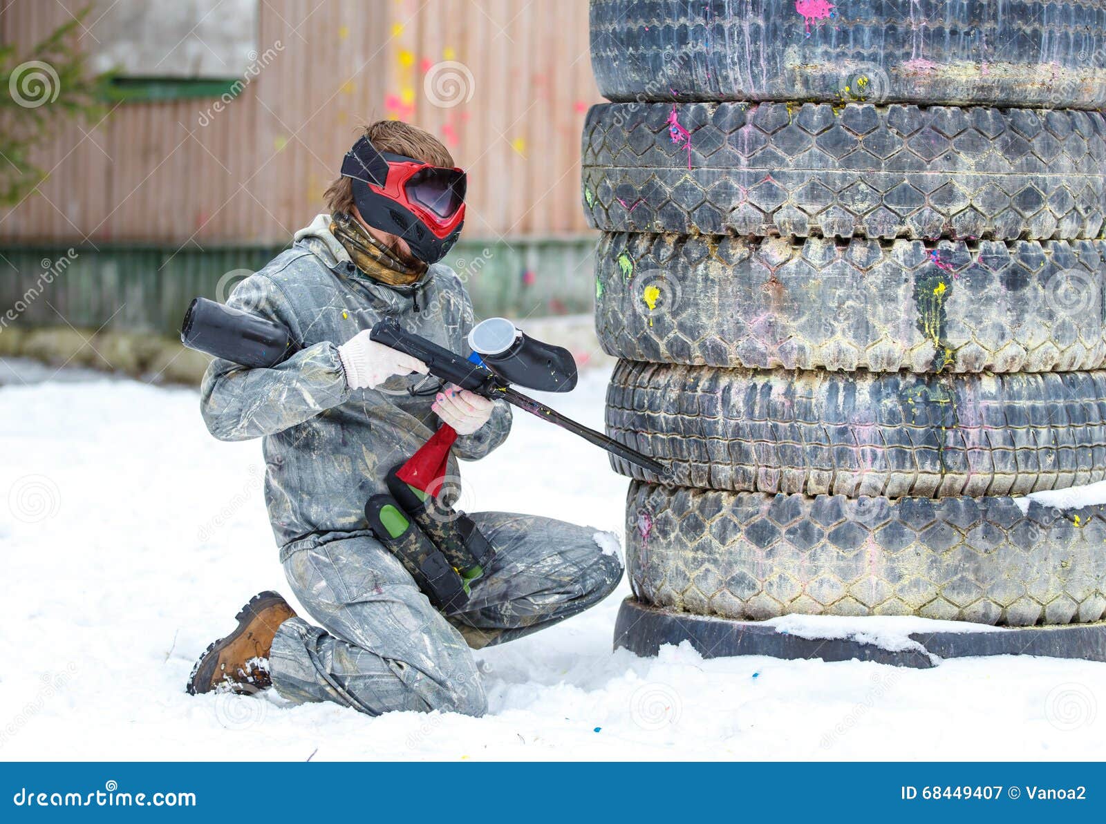 Paintball Game in Winter. Cool Shooter Behind Fortification. Stock
