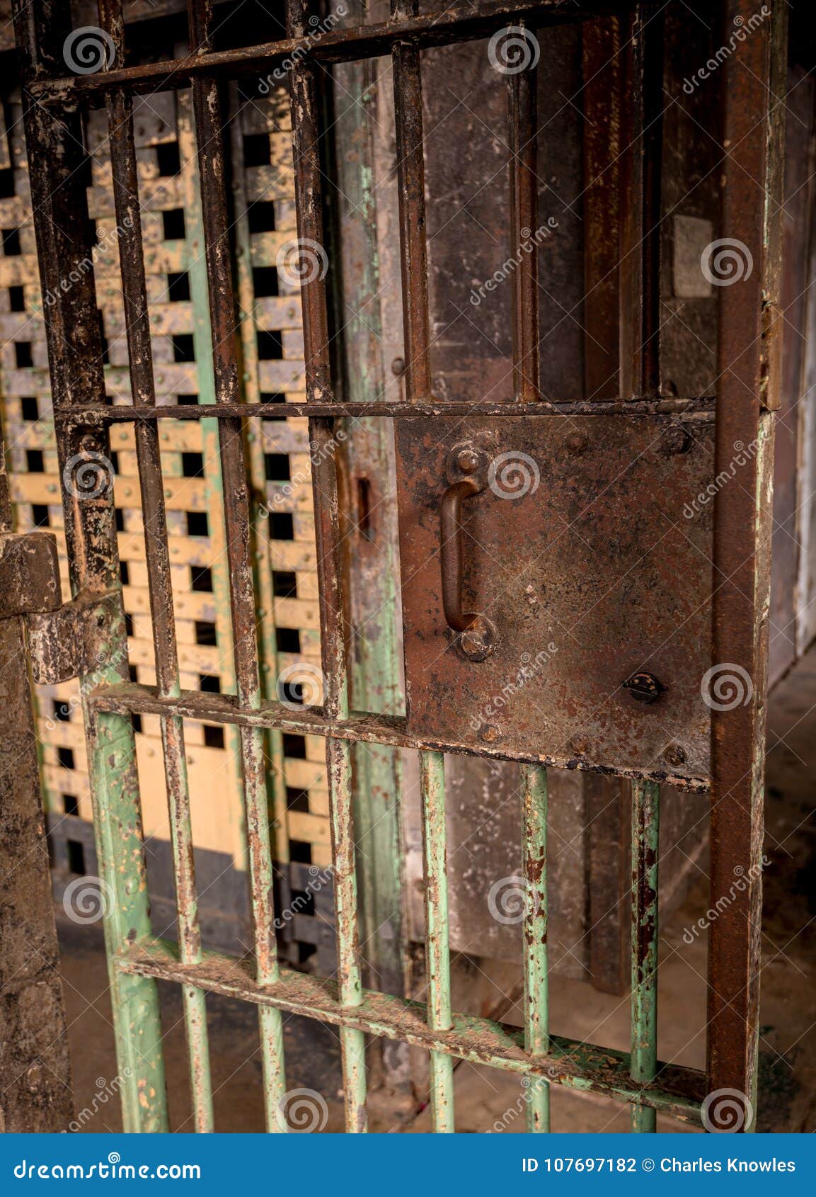 Painted And Rusted Old Prison Door Leads To A Corridor Stock Photo