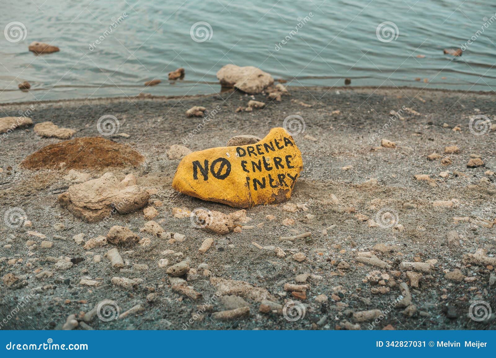 painted warning rock near water's edge in bonaire