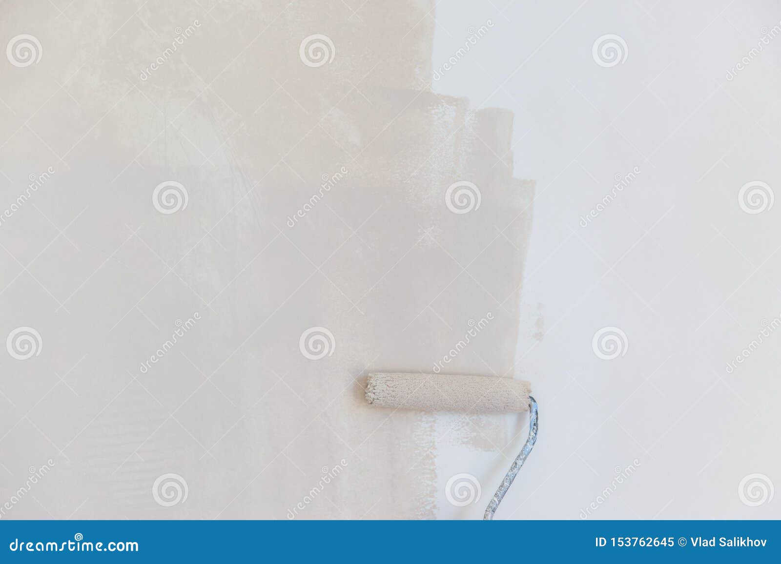 Painter Hand in White Glove Painting a Wall with Paint Roller Stock