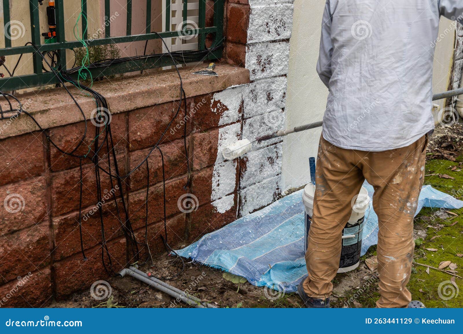 Painter Worker Adding Undercoat Foundation Paint Onto Wall with Roller