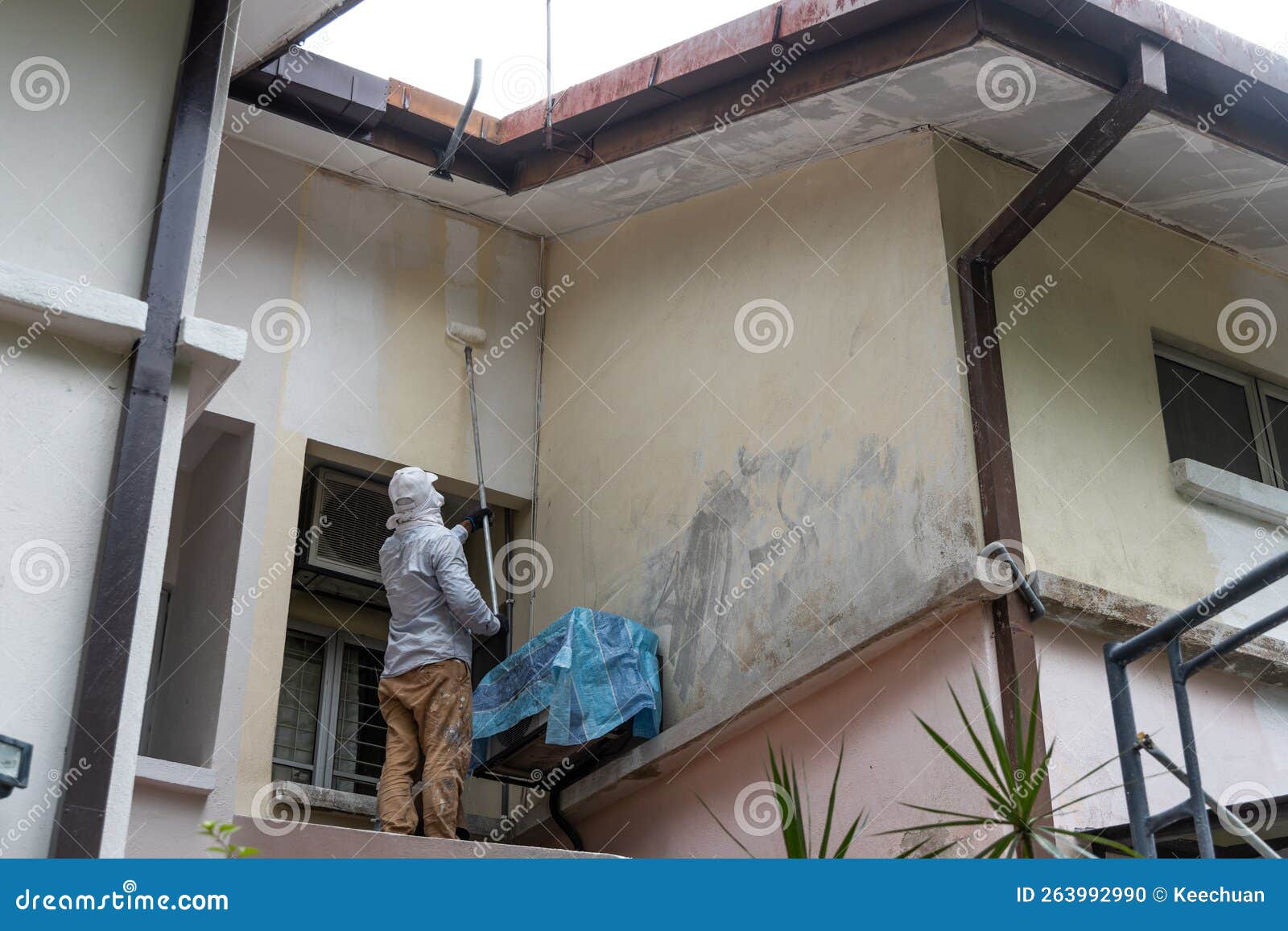 Painter Worker Adding Undercoat Foundation Paint Onto Wall with Roller