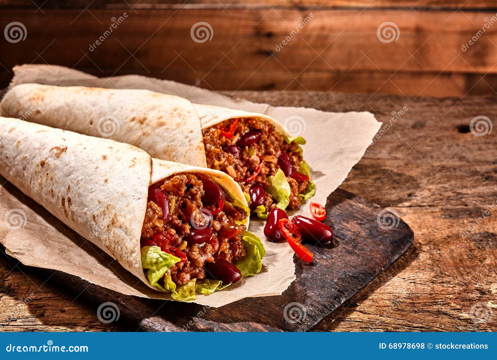 pair of chili stuffed tex mex wraps on wood table