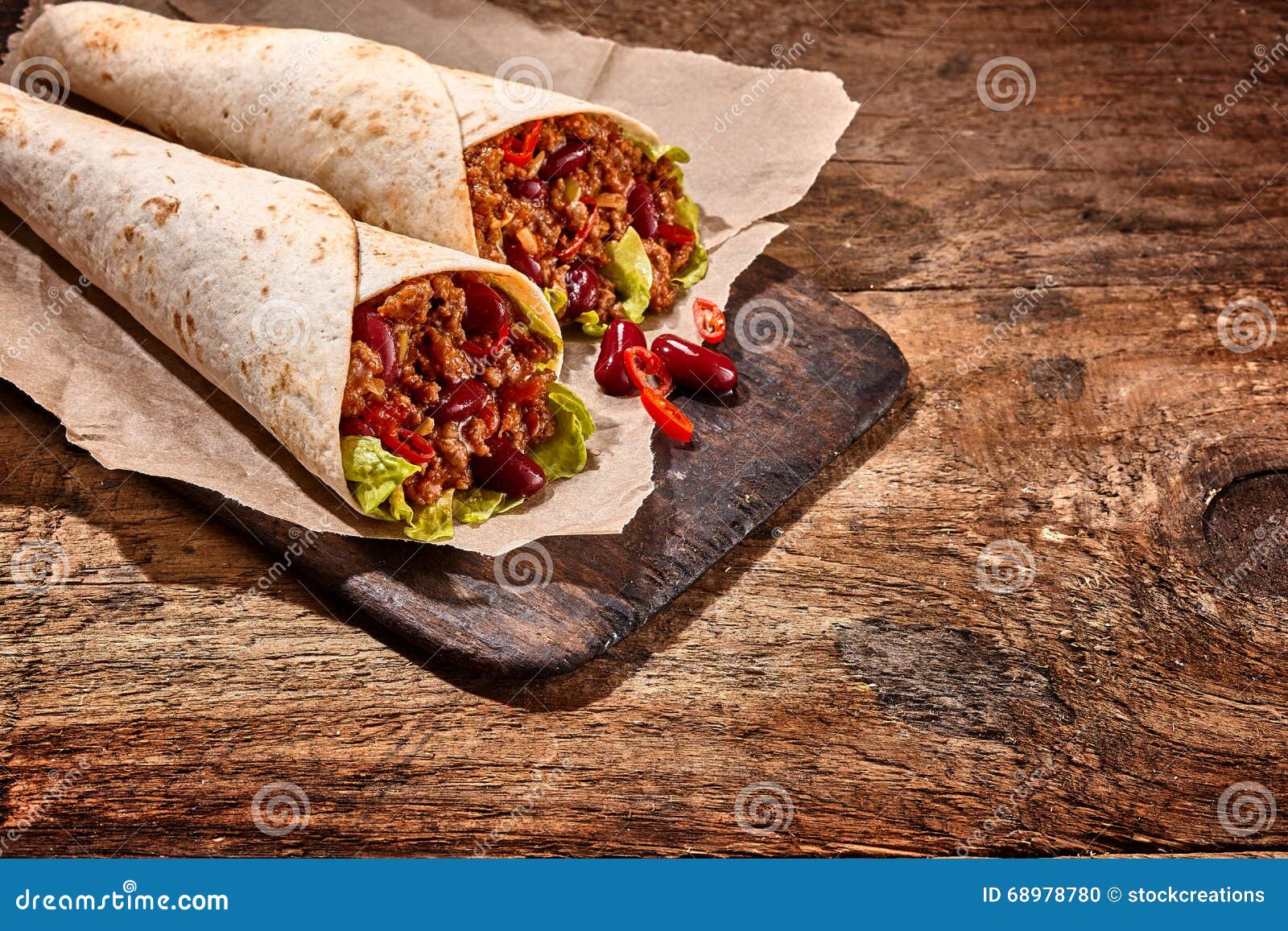 pair of chili stuffed tex mex wraps on wood table