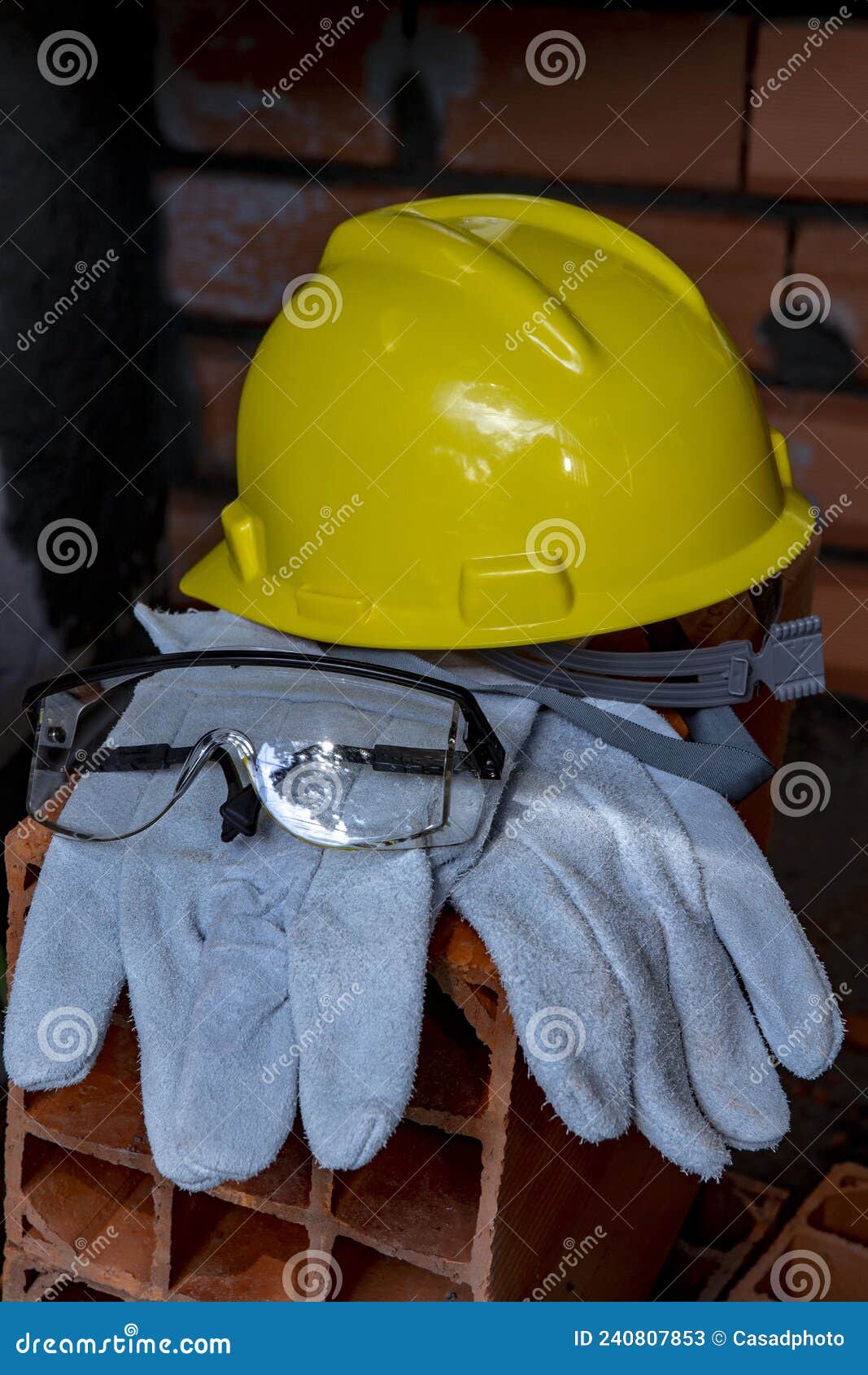 gloves, helmet and mason`s goggles on pile of bricks