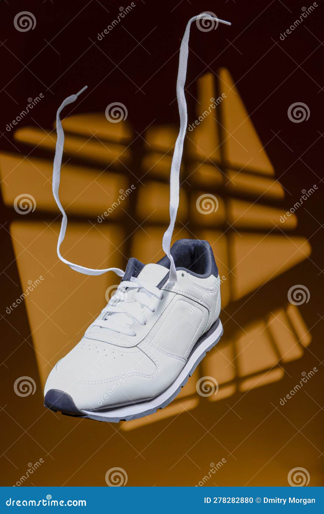 Pair of New White Sneaker with Flying Shoelaces Placed Over Yellow ...