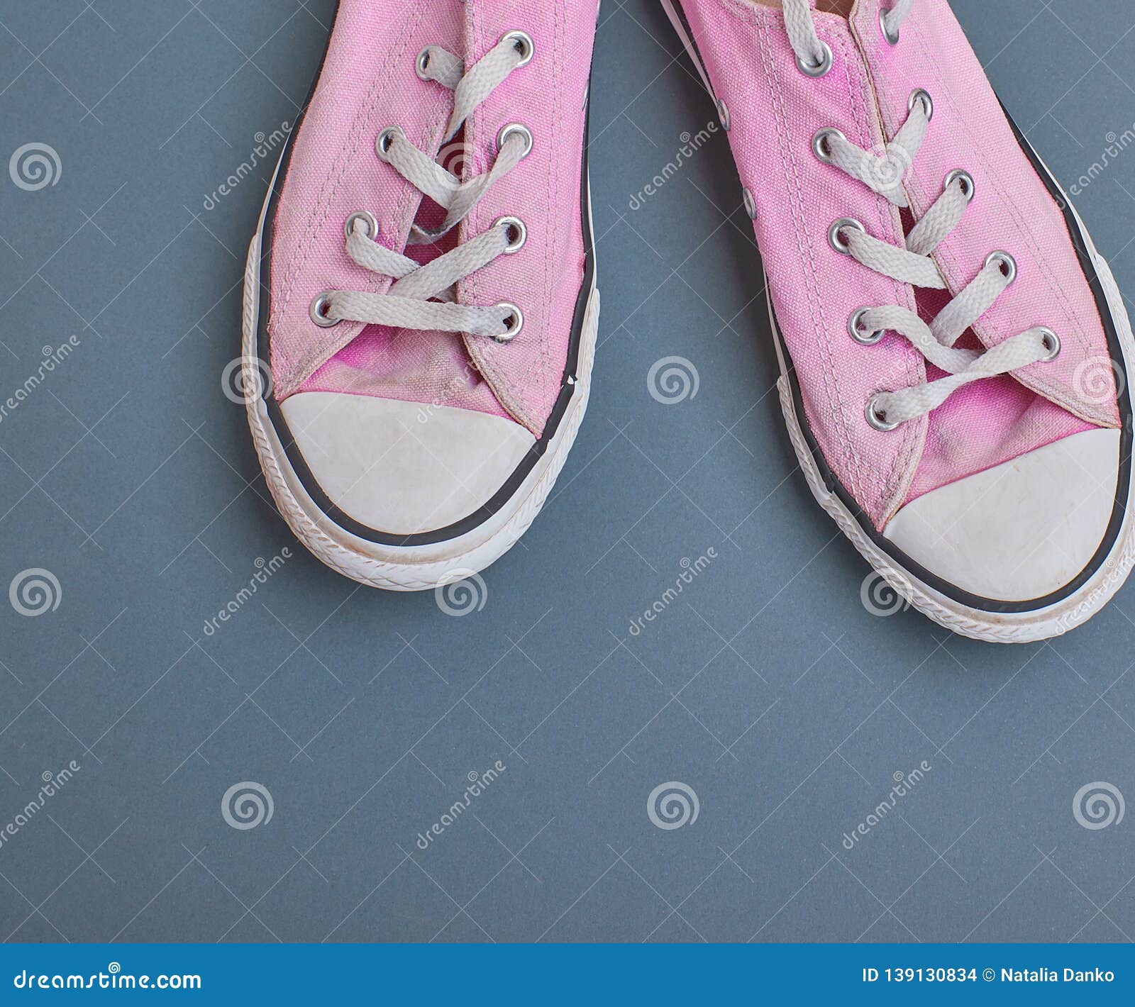 Pair of Old Worn Pink Sneakers with White Laces on a Black Background ...