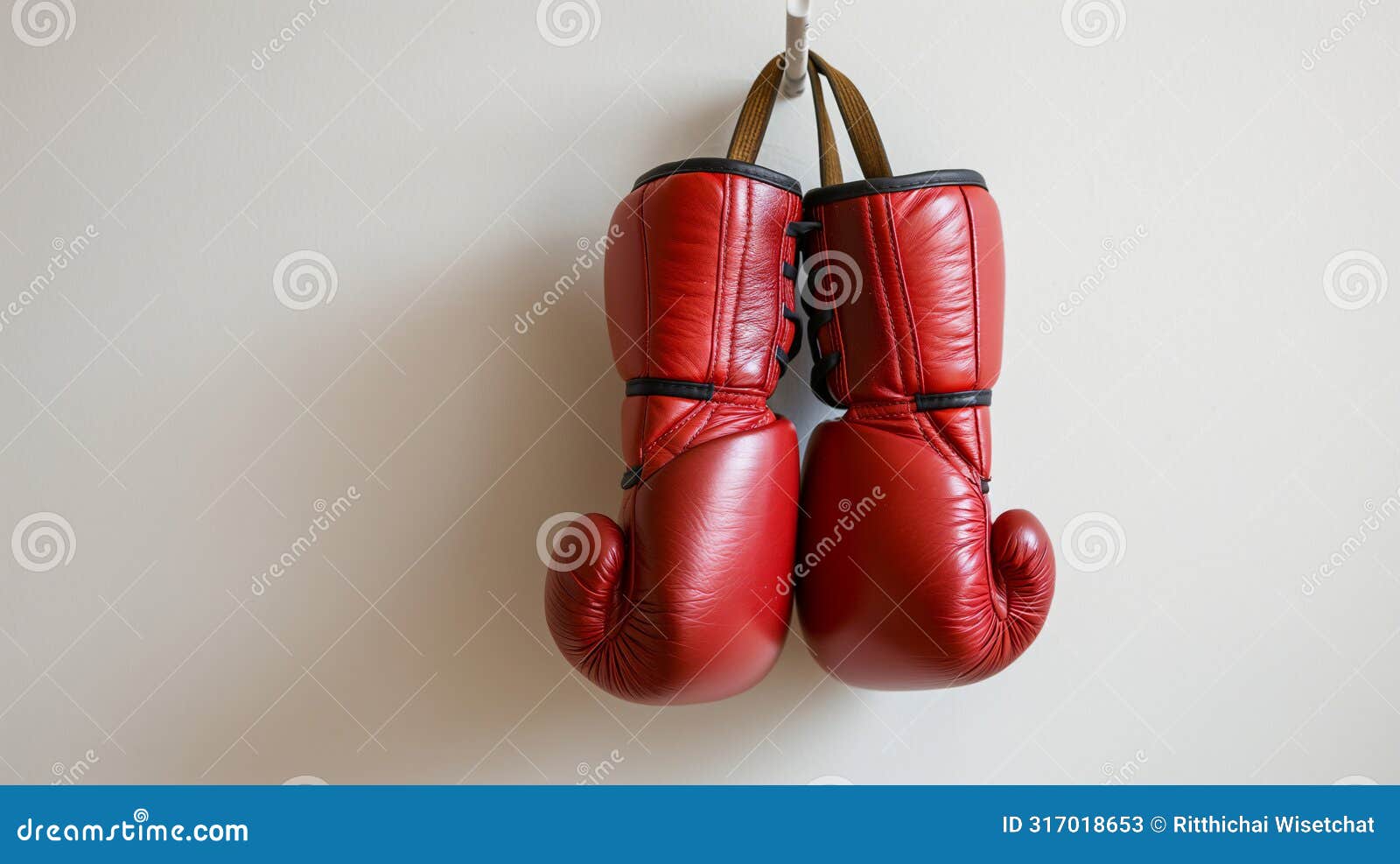 a pair of red boxing gloves hangs on a white wall, izing readiness and strength in sports