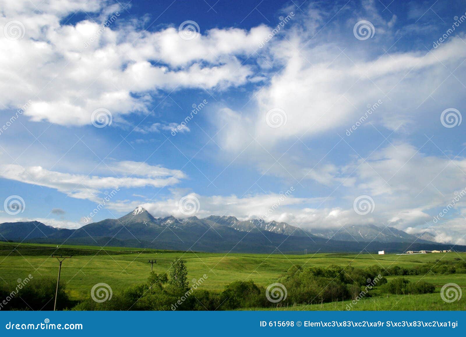 Paisagem nebulosa com montanhas. Ajardine com nuvens e o Tatras elevado no fundo.