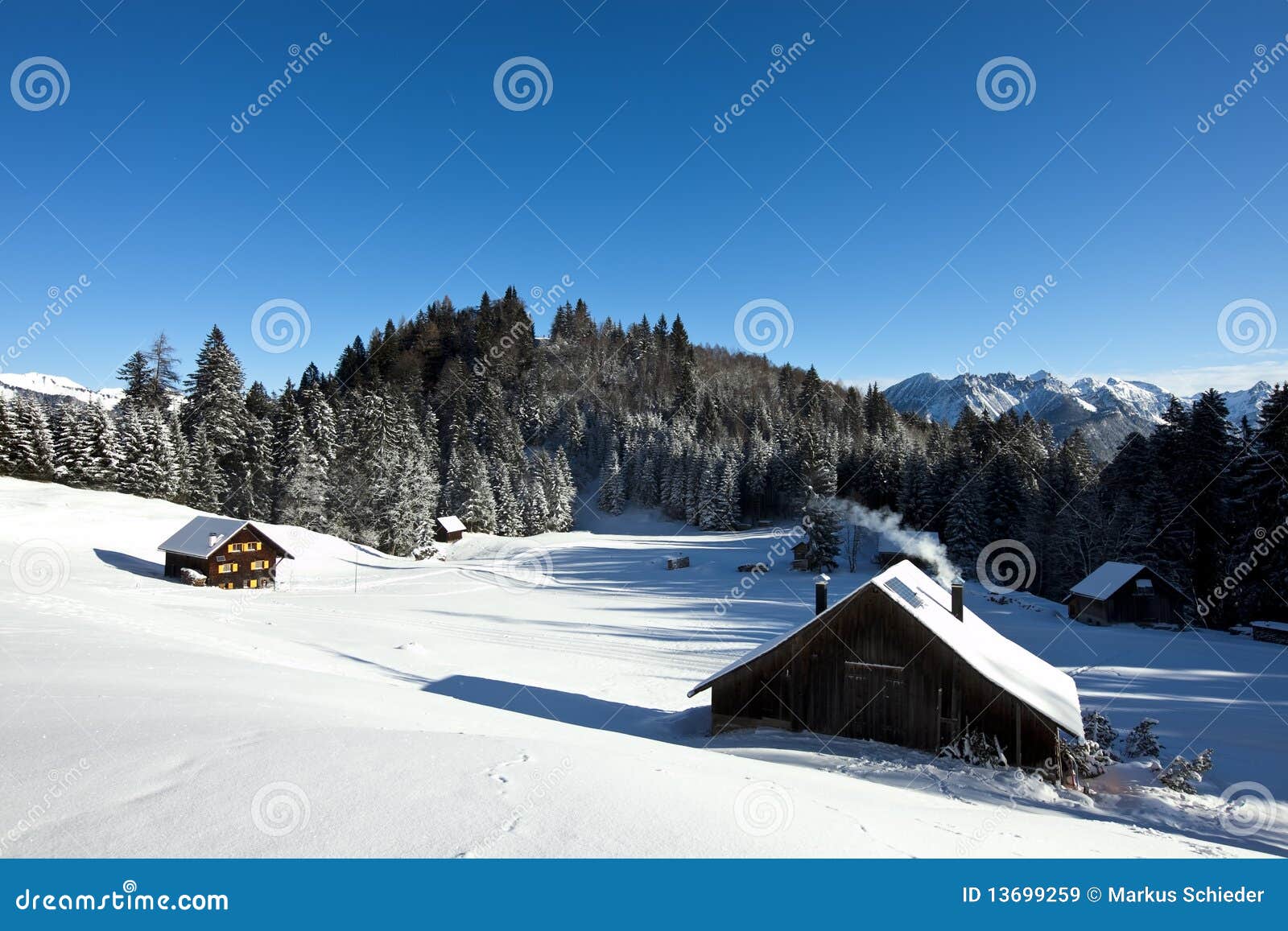 Paisaje del invierno con la cabina de registro. Paisaje asoleado rural del invierno con las cabinas de registro ocupadas en las montañas