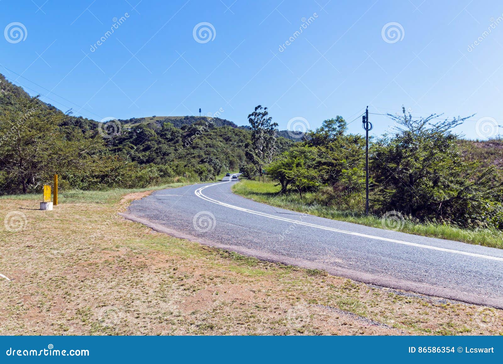 Paisaje rural de Asphalt Road Curving Through Rural. Carretera de asfalto rural que curva con paisaje rural de la vegetación verde en Shongweni cerca de Durban, Suráfrica
