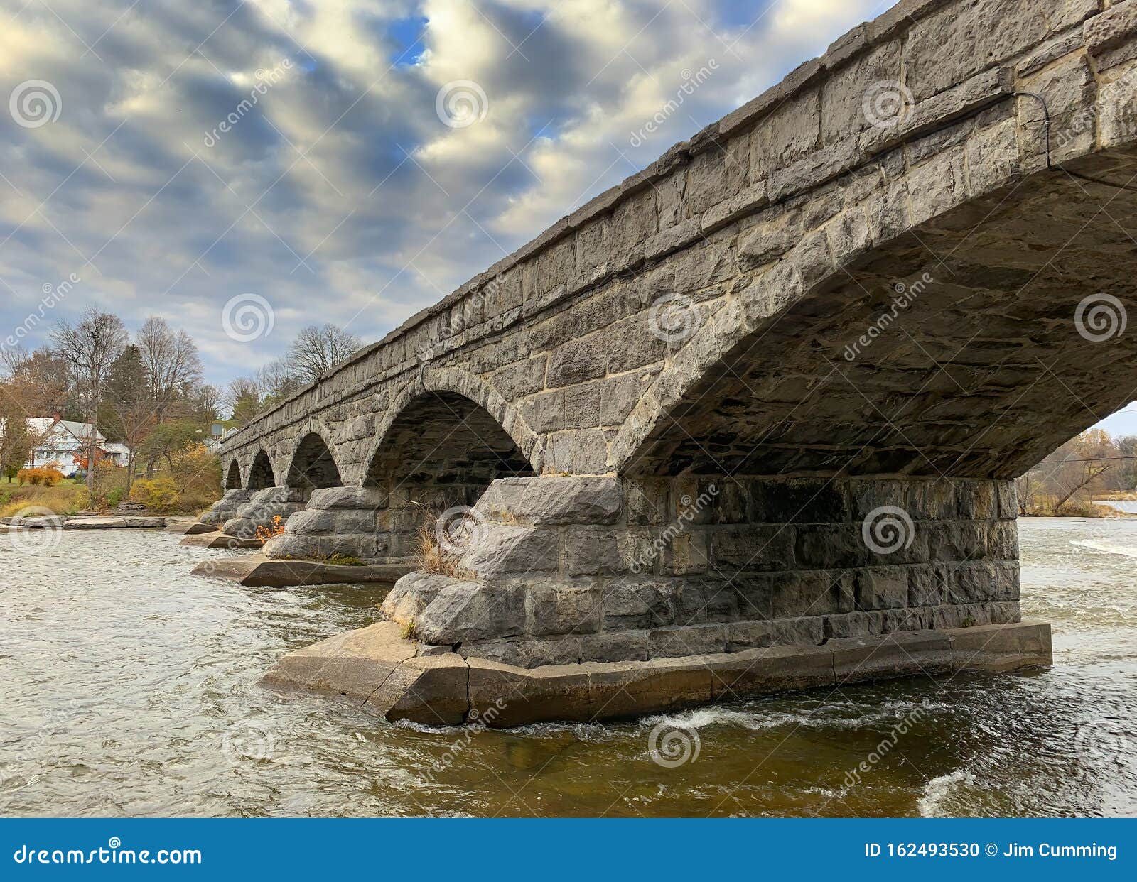 pakenham bridge, a five span stone bridge that crosses the mississippi river on a cloudy autumn day in pakenham, canada