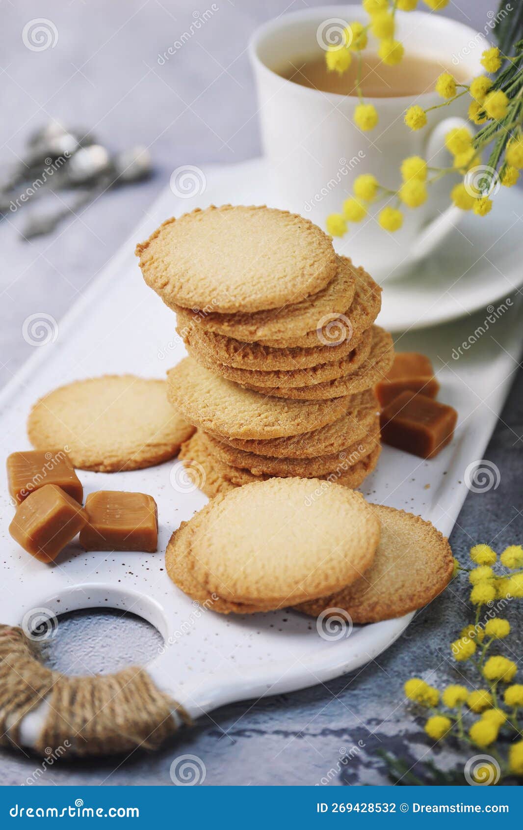 palets bretons, french cookies. salted caramel shortbread breton cookies, cup of coffee and bouquet of mimosa