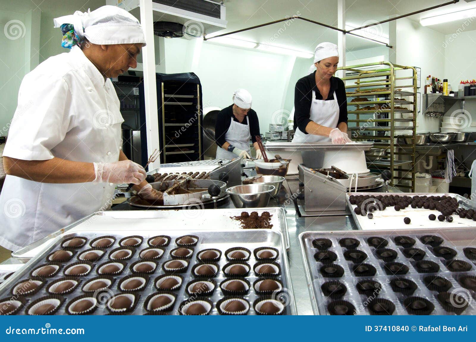 Palle del cioccolato. KERIKERI, NZ - 7 GENNAIO: L'operaio del cioccolato prepara le palle immerse del cioccolato il 7 gennaio 2014. Nel 2006 più di 6,5 milioni di tonnellate di cioccolato sono stati venduti universalmente.