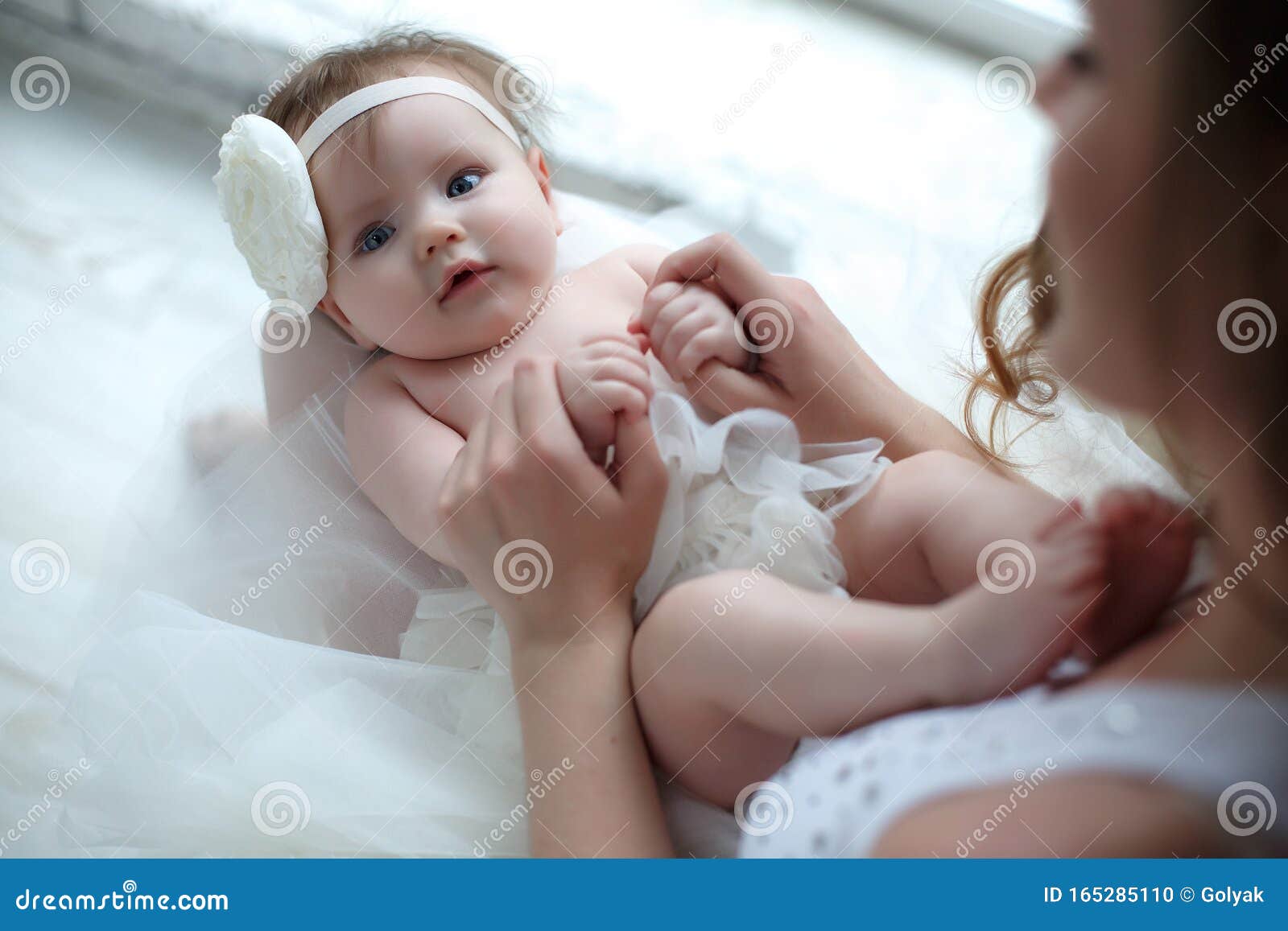 small hands of a newborn baby in the tender palms of a caring mother