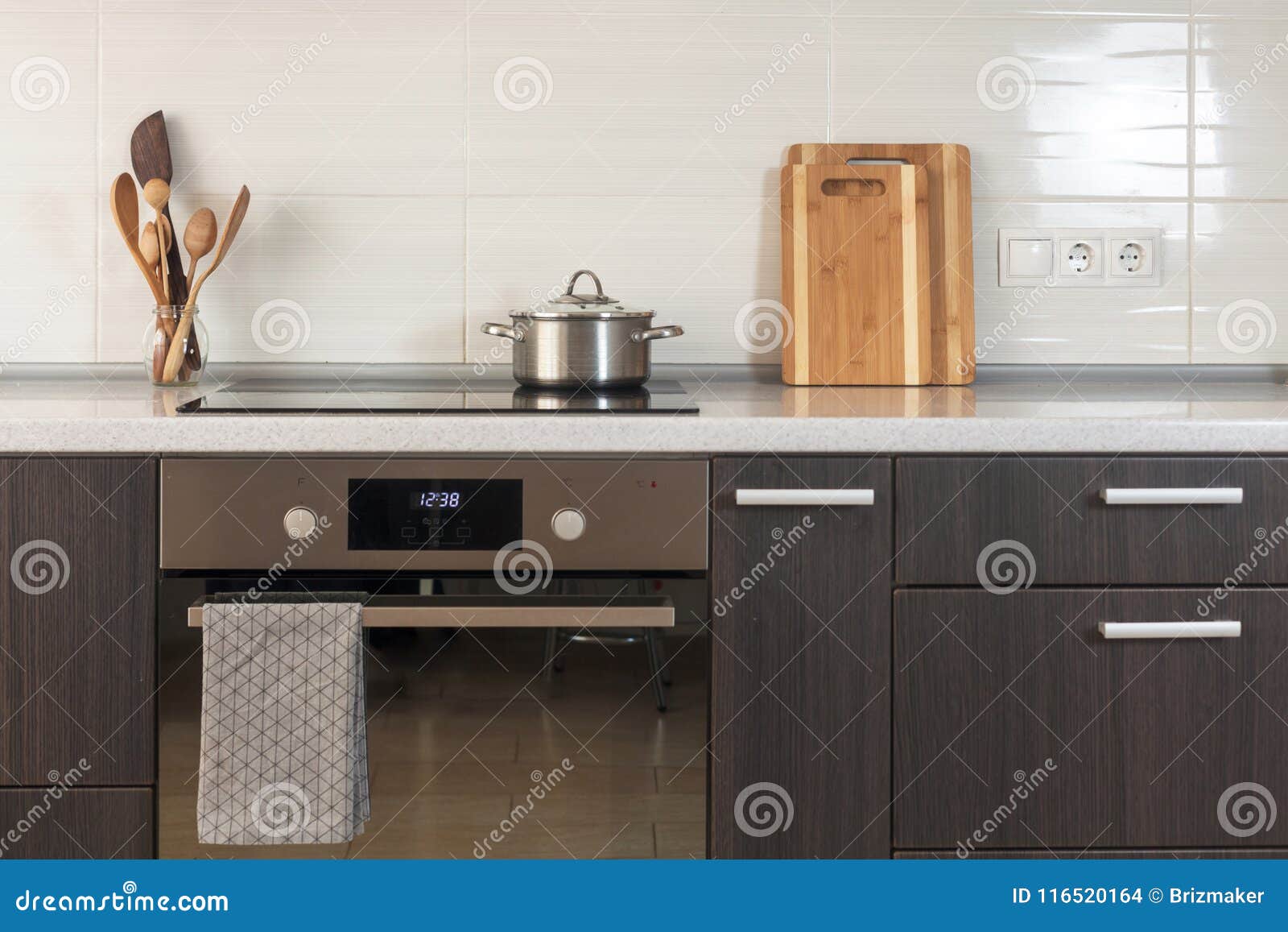 The Pan is on a Ceramic Stove. Light Kitchen with Oven, Cutting Board