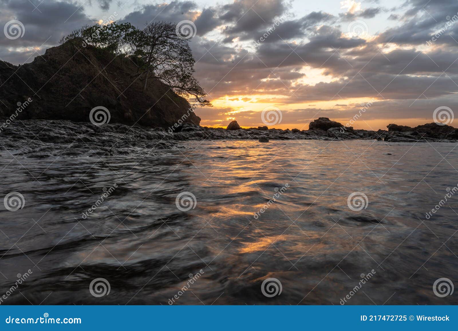 sunset beach on high tide with rock