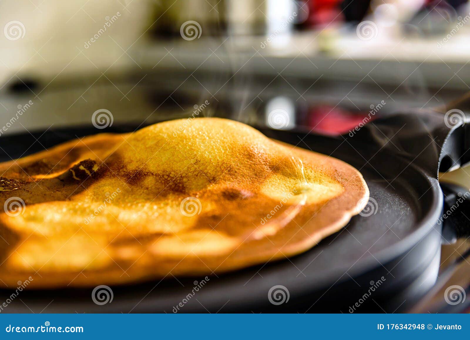 Pancake Frying Pan with Crepe Pancake Cooking on Cooker in Kitchen