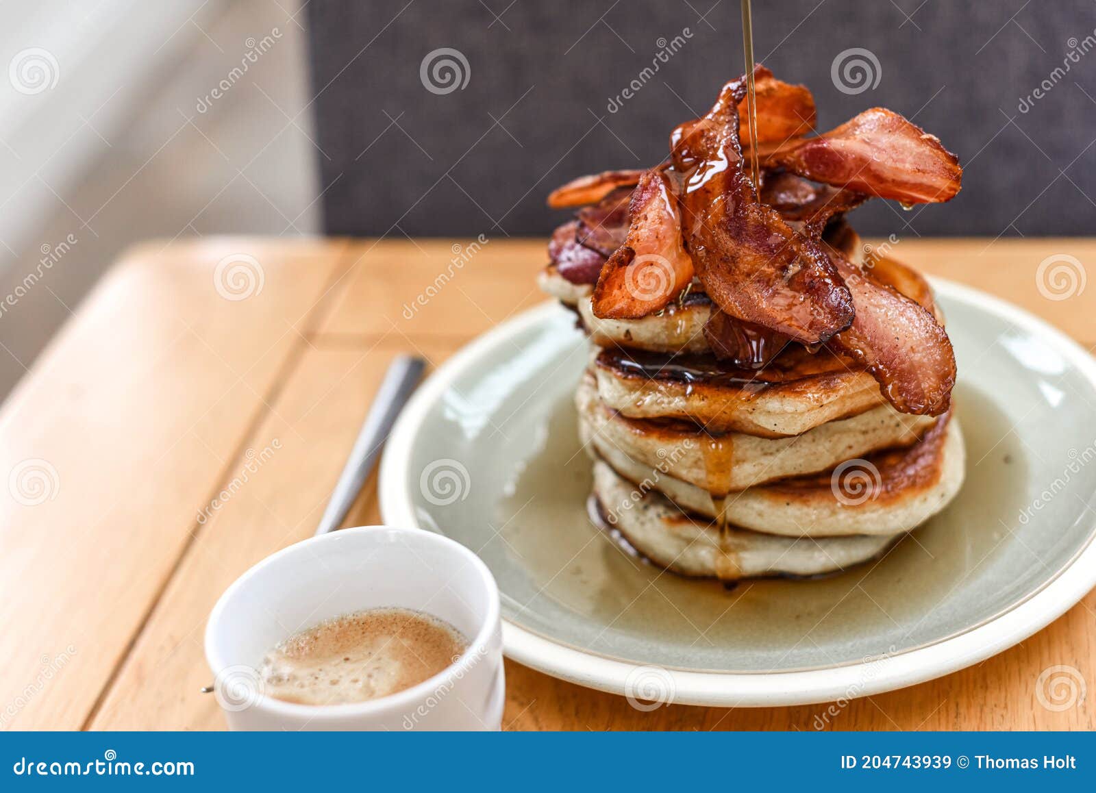 Pancake Stack with Golden Syrup and a Large Portion of Bacon As a