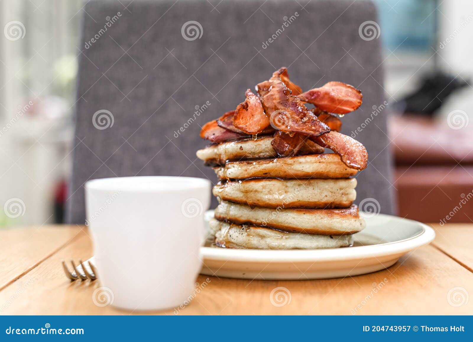 Pancake Stack with Golden Syrup and a Large Portion of Bacon As a