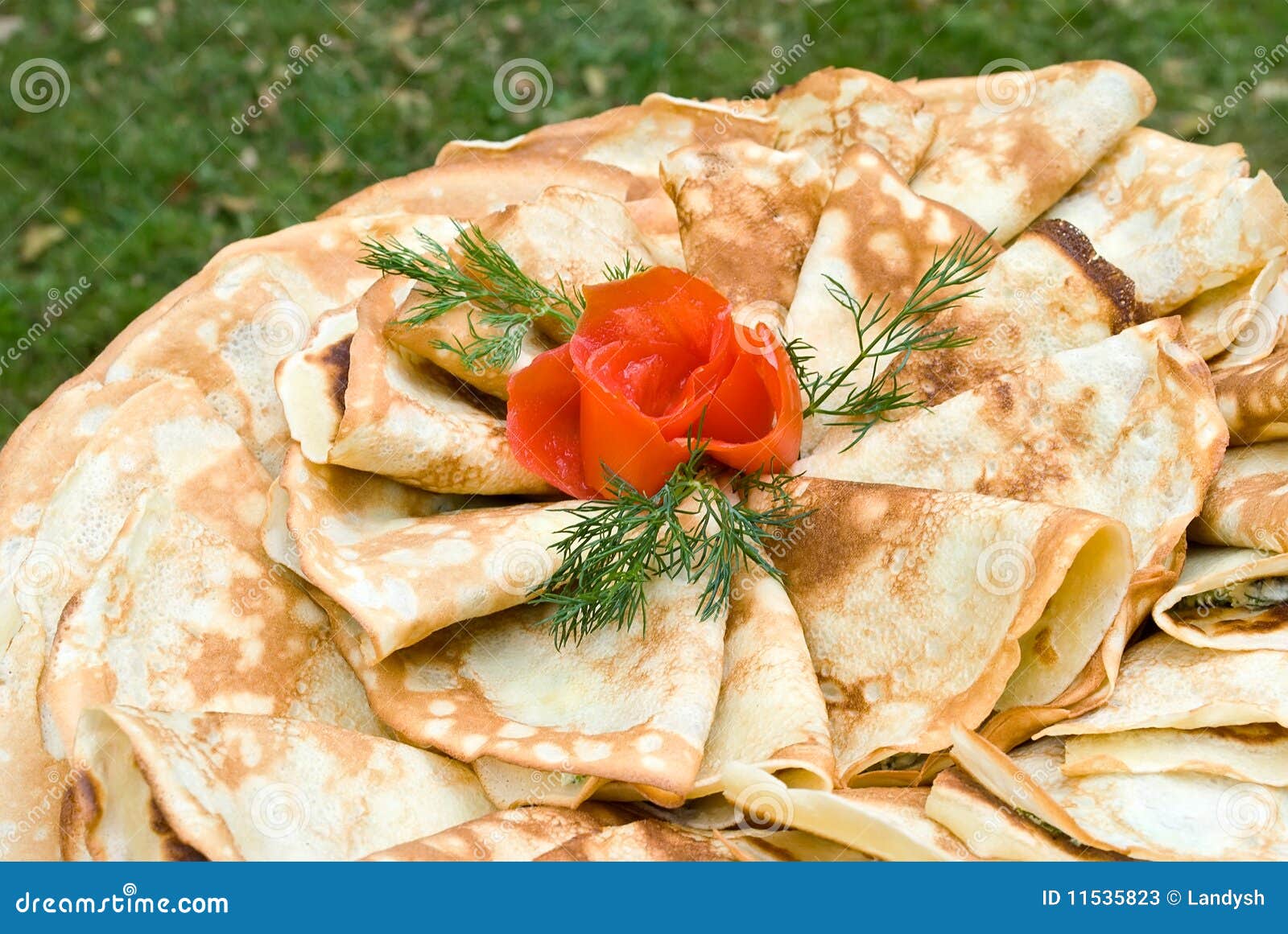 Pancakes decorated with tomato rose. Pancakes stuffed with feta cheese and spinach and decorated with tomato rose and dill