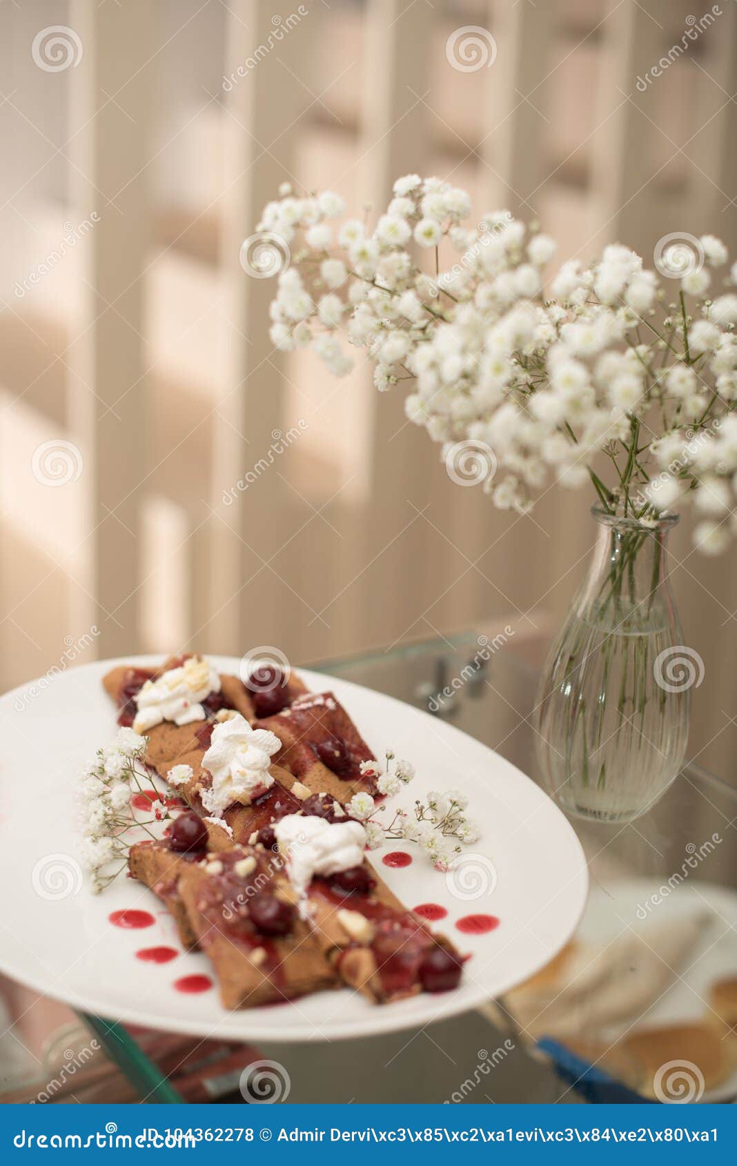 pancakes on plate with decorations and flowers in vase