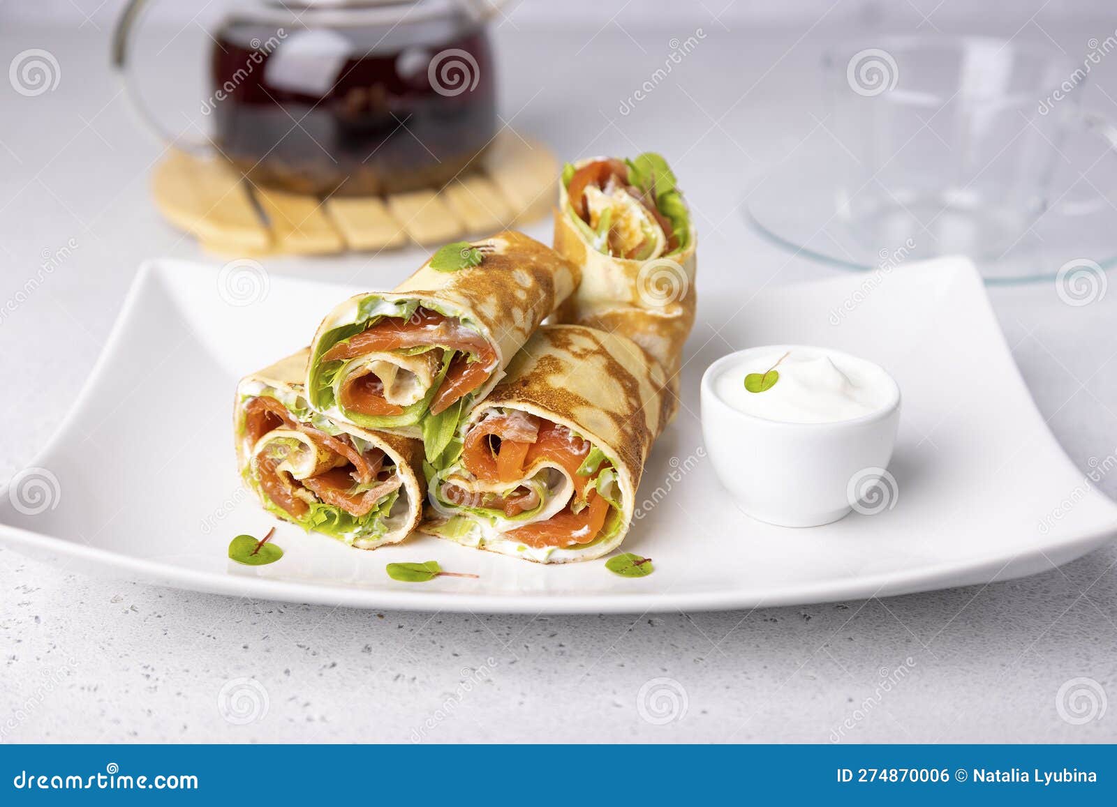 pancakes with salmon (trout), sour cream, greenstuff and tea. thin, not sweet blinchiki stuffed with red fish.