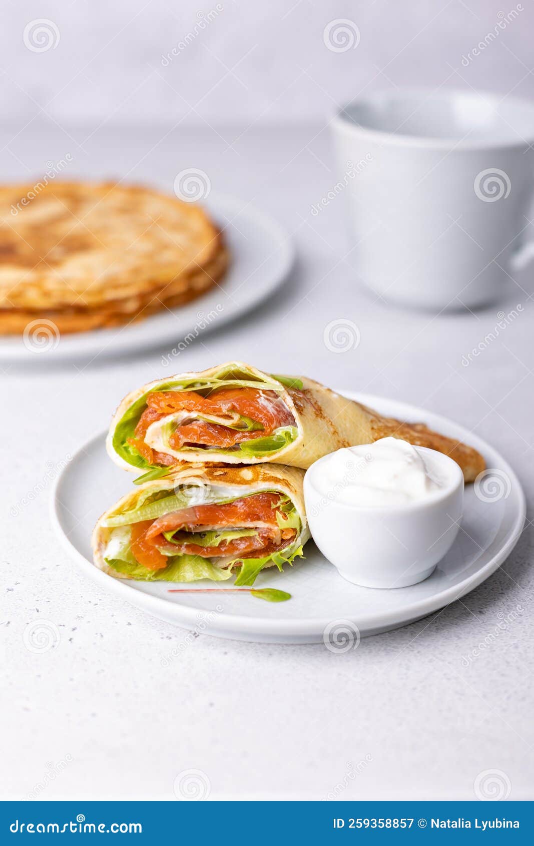 pancakes with salmon trout, sour cream and greenstuff. thin, not sweet blinchiki stuffed with fish. traditional russian dish.