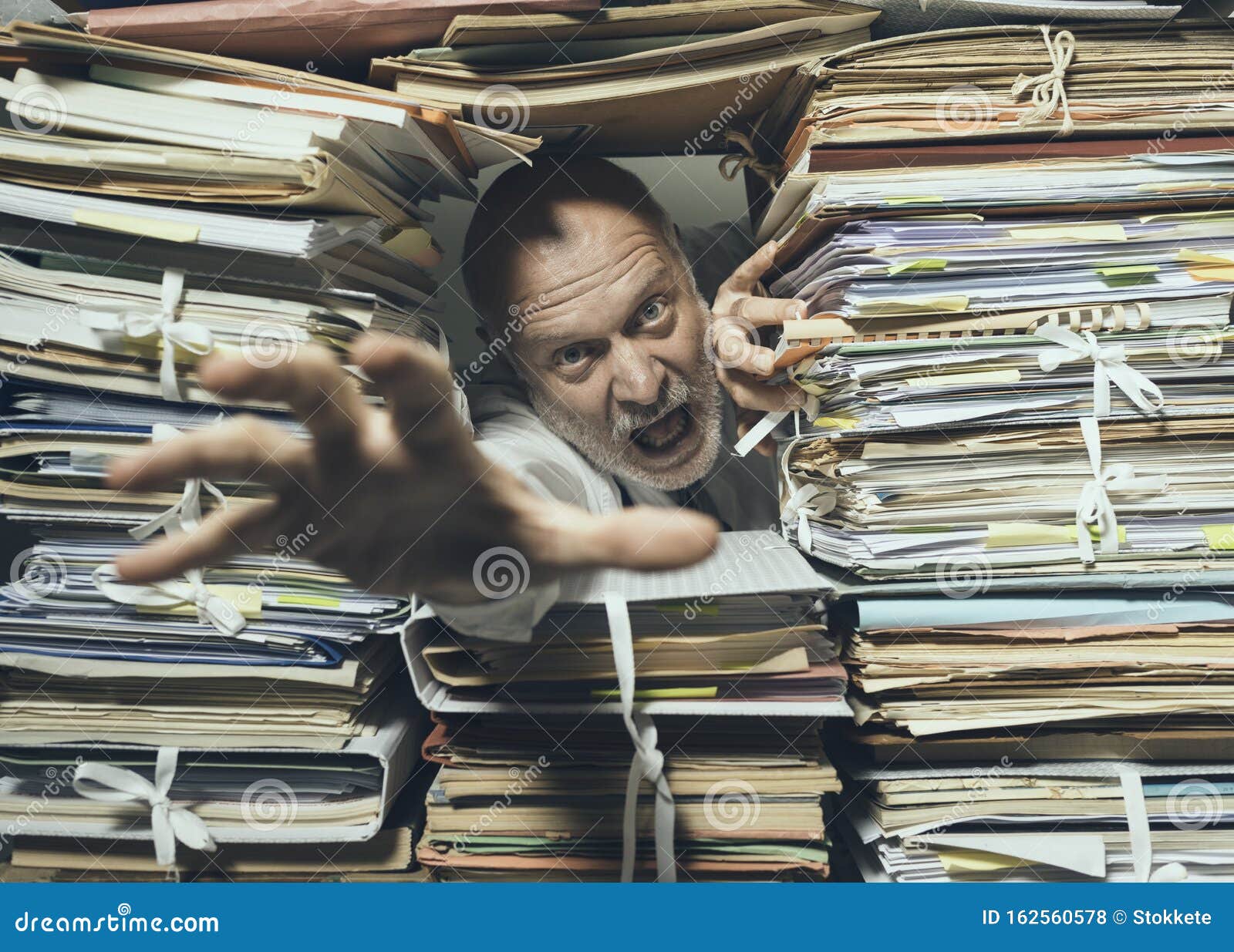 panicked businessman overloaded with paperwork