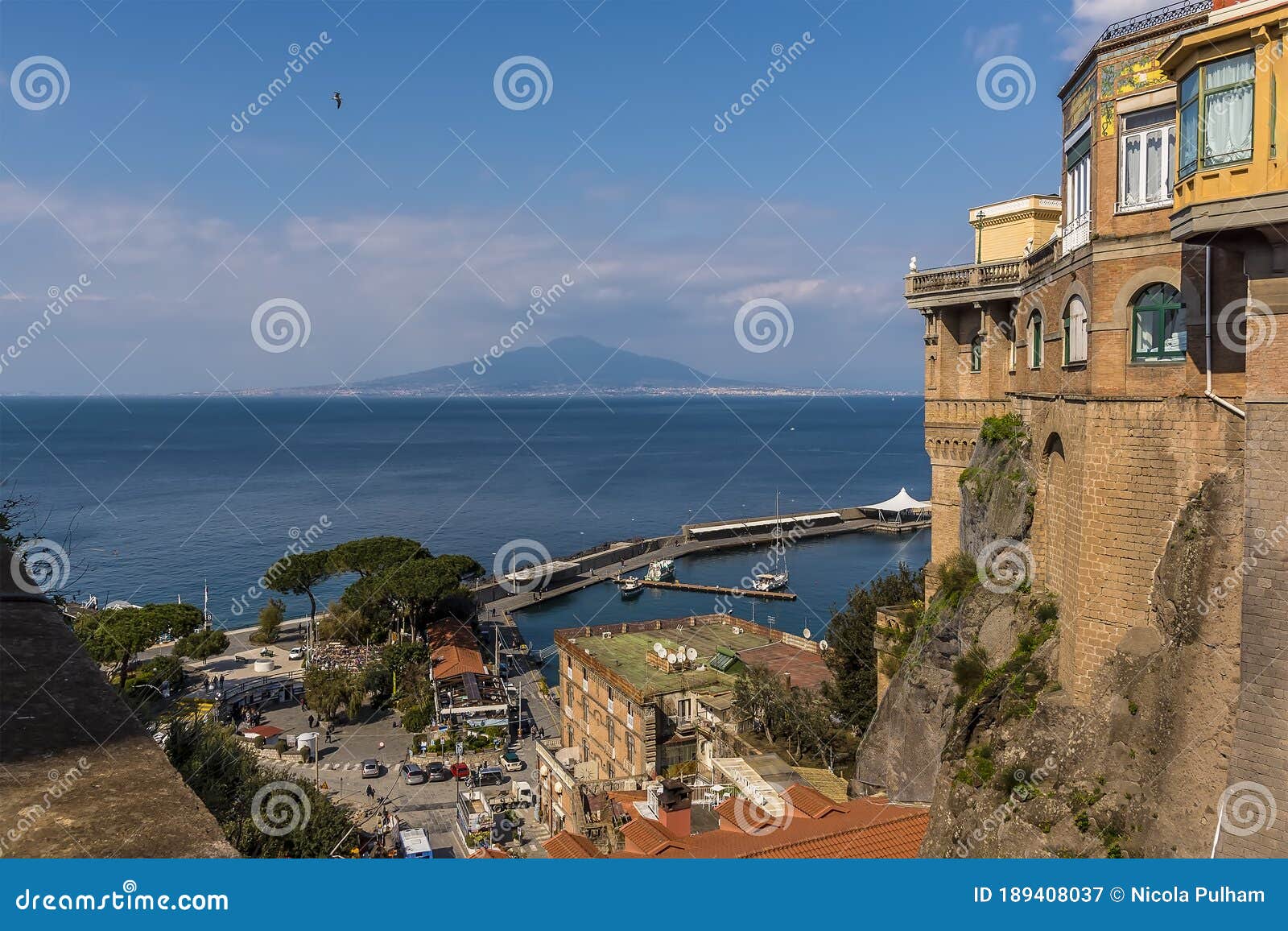 a panorama view down from the cliffs of sorrento, italy across the bay of naples towards mount vesuvius in the distance
