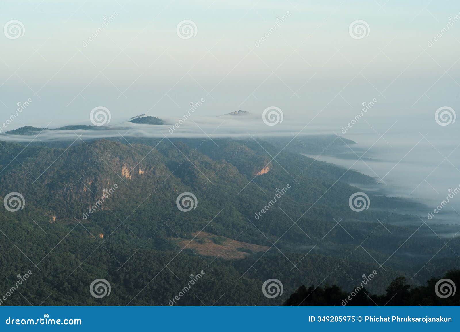 panorama view layers of mountain with the fluffy white fog between the mountains and clear sky in background