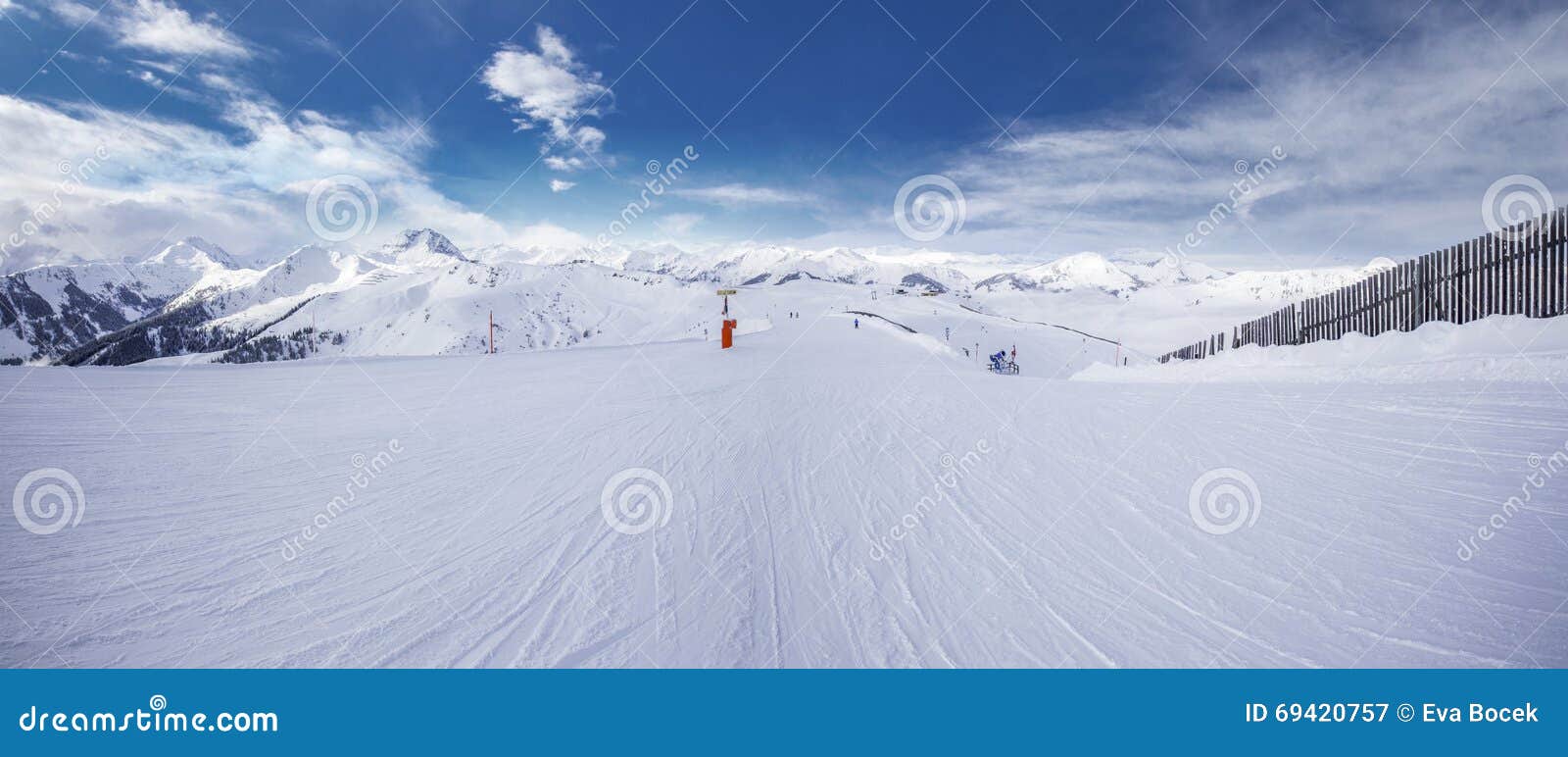 panoramaview to ski slopes and skiers skiing in kitzbuehel mountain ski resort with a background to alps in austria