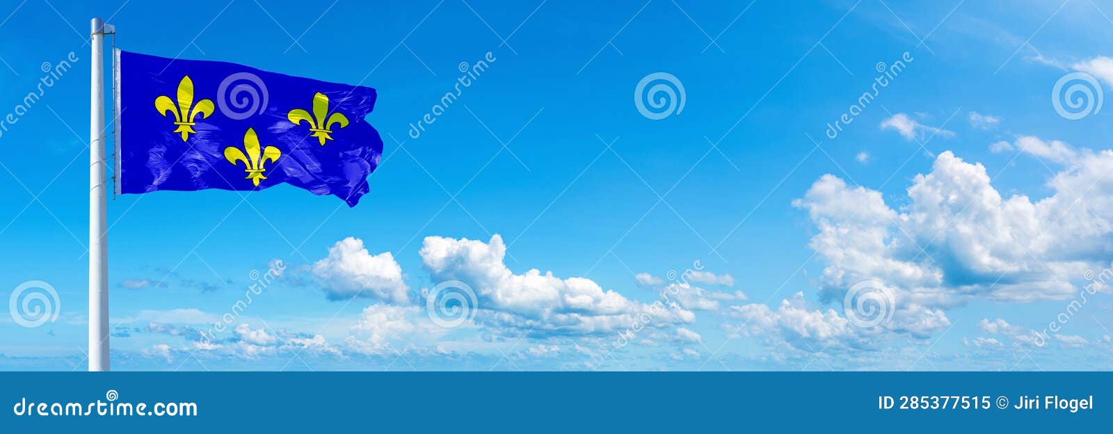 ile-de-france flag - state of france, flag waving on a blue sky in beautiful clouds - horizontal banner