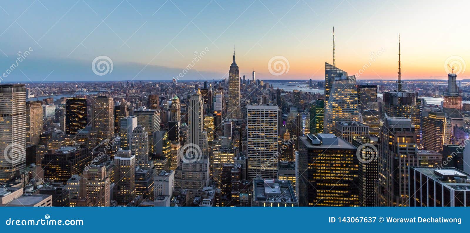 panoramic photo of new york city skyline in manhattan downtown with empire state building and skyscrapers at night usa