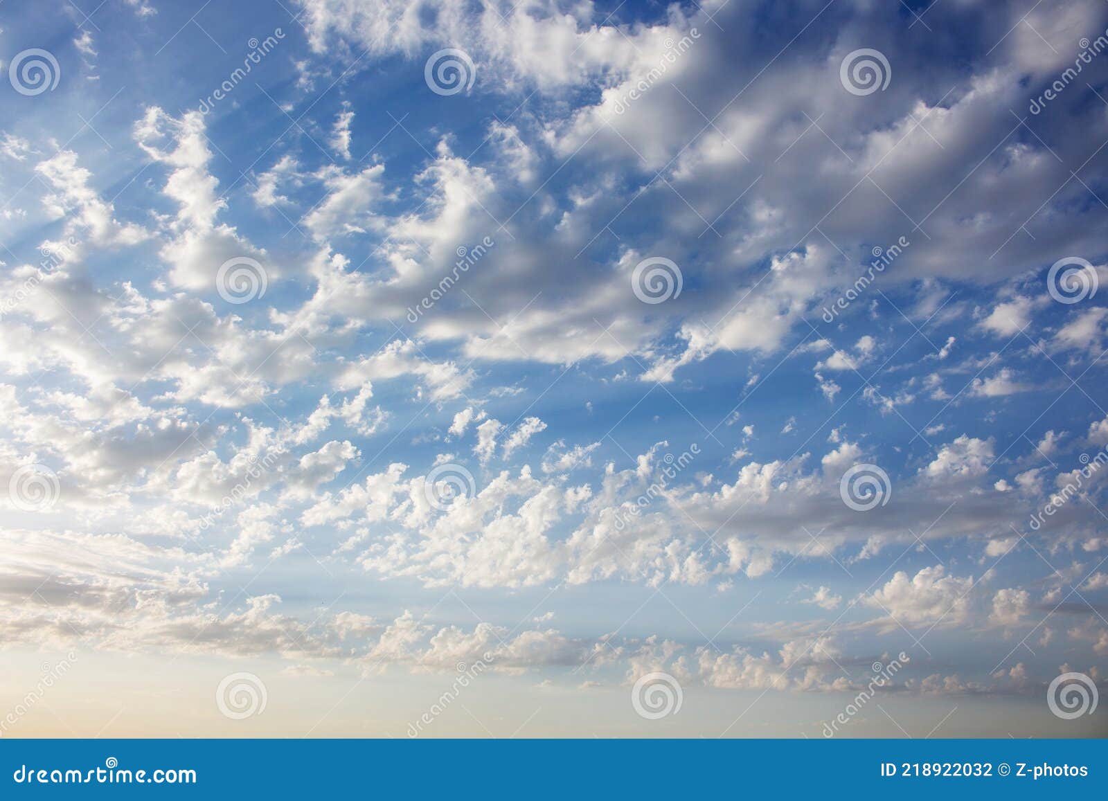 panoramic view of the beautiful blue sky with fluffy white clouds, illuminated by the sun`s rays. cloudcape.