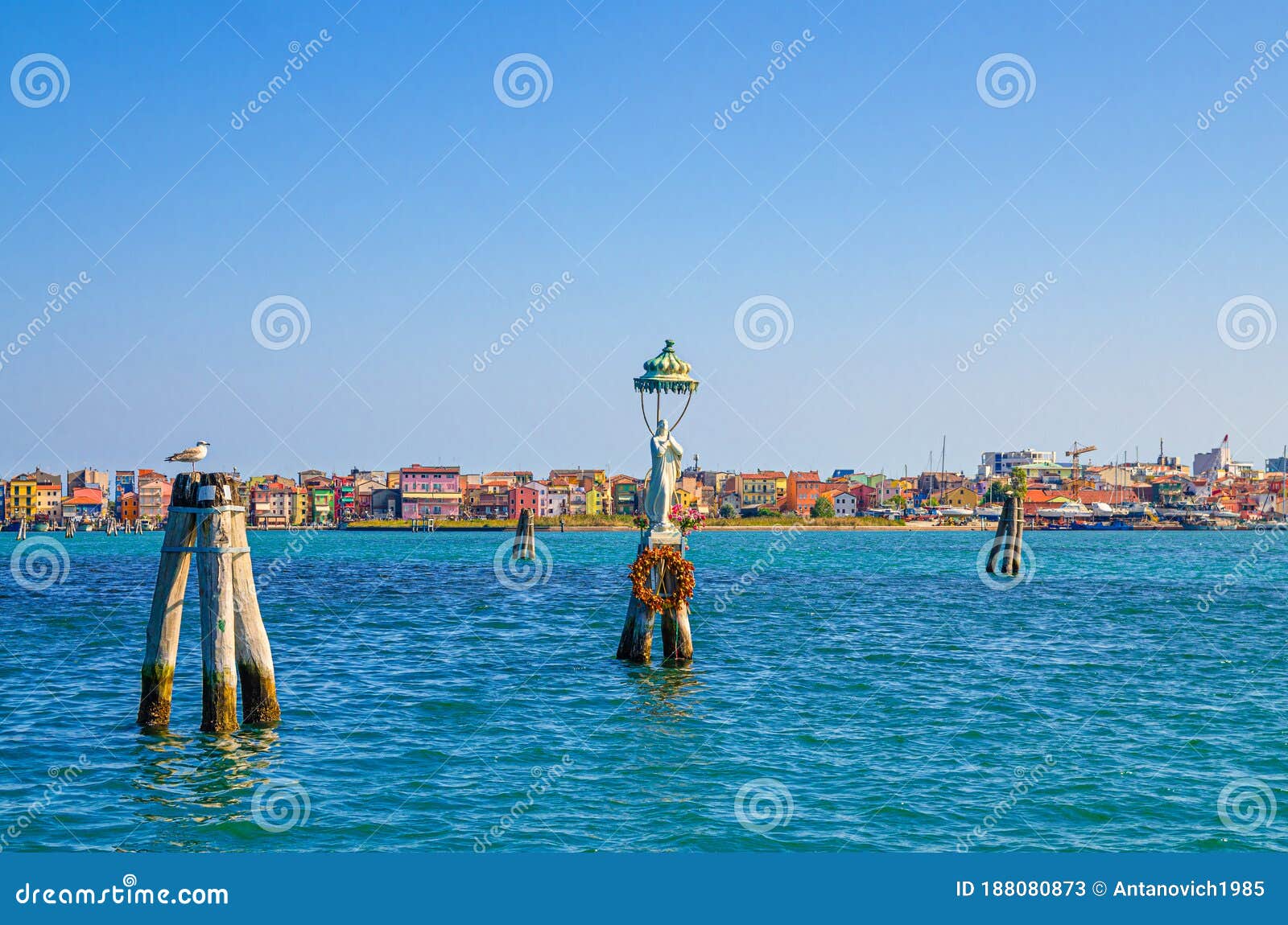 panoramic view of lusenzo lagoon with wooden bricole poles in water and sottomarina town