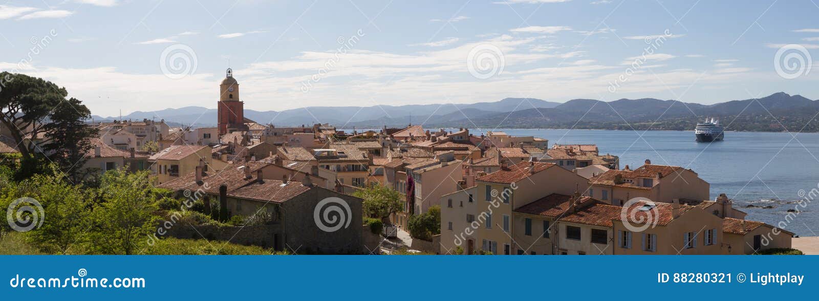Panoramic view on Saint Tropez France and its bay. A cruise ship is anchored in the bay.