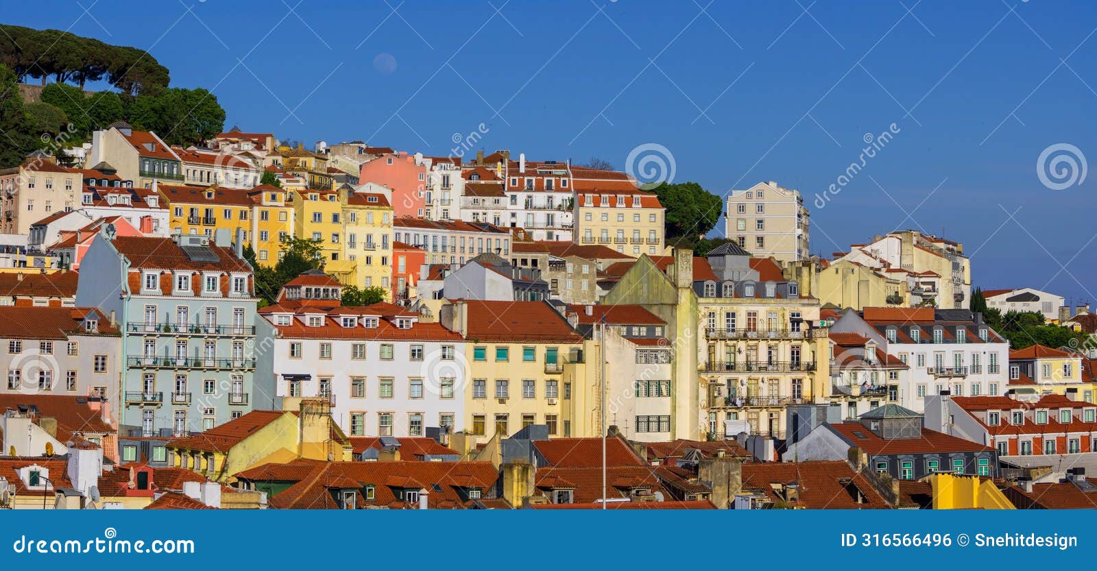 panoramic view of skyline of lisbon city, portugal, many colorful houses against blue sky in the alfama district