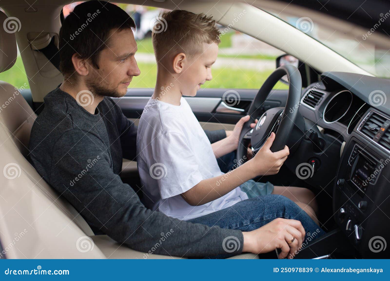 Mignon Petit Garçon Au Volant De La Voiture Des Pères