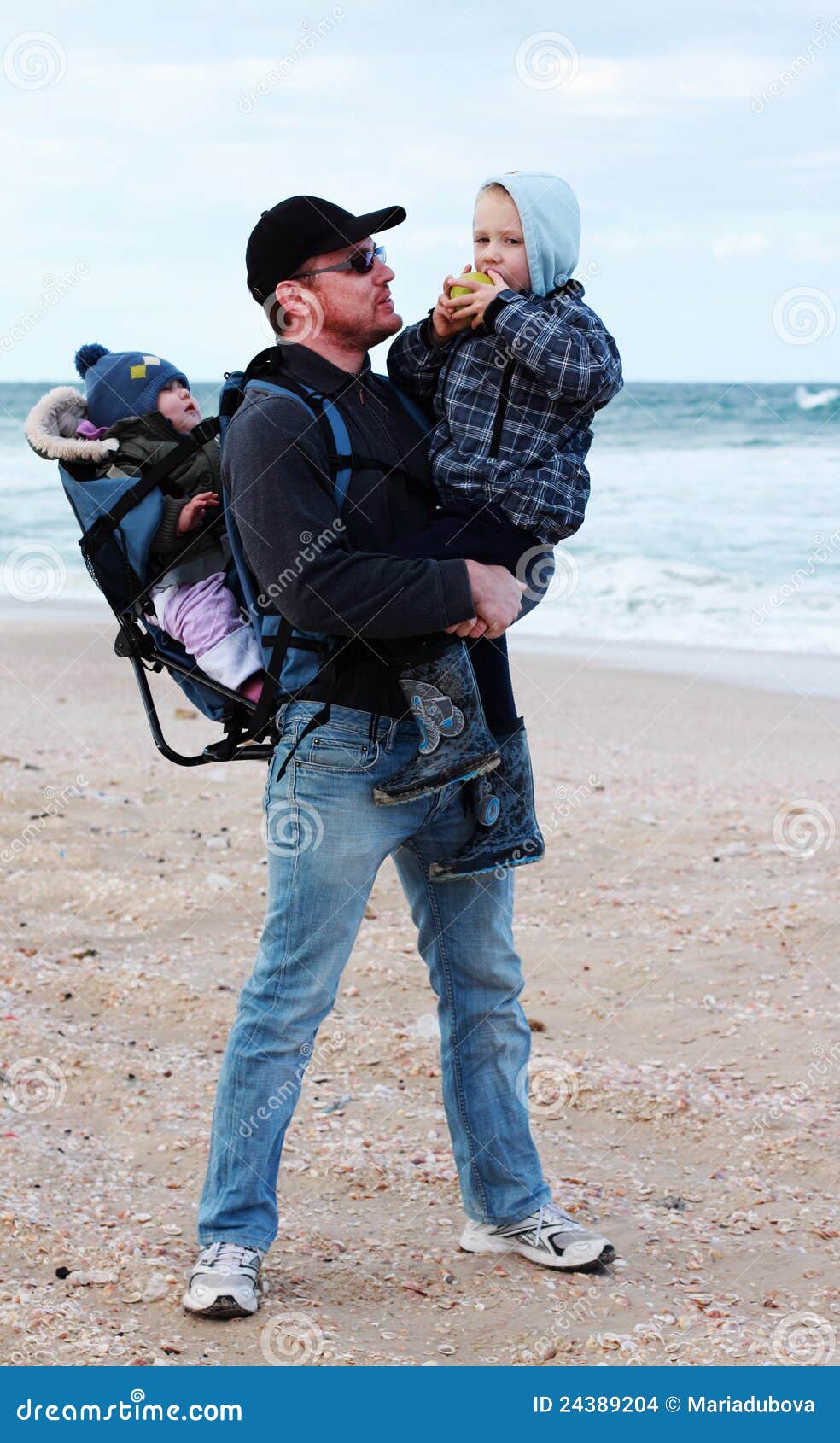 Papa, zoon en dochter tijdens een gang langs het overzees die van de golven loopt
