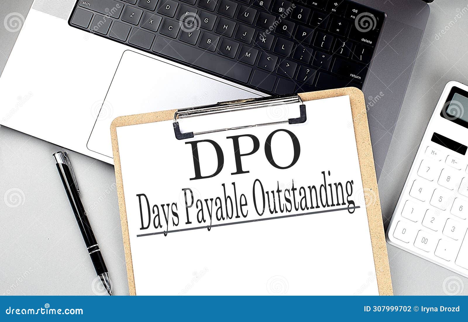 paper clipboard with dpo days payable outstanding on laptop with pen and calculator