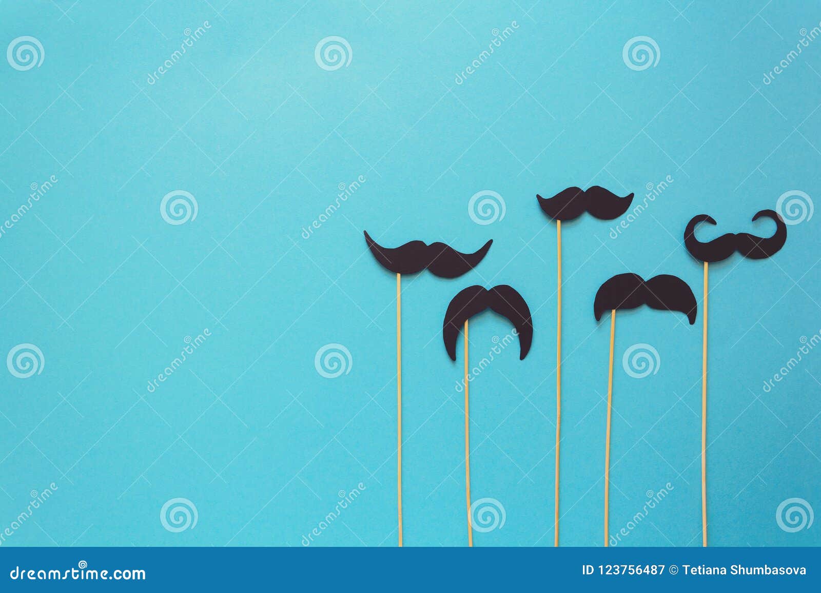 paper mustache on booth props on blue paper background. cut out style. movember concept.