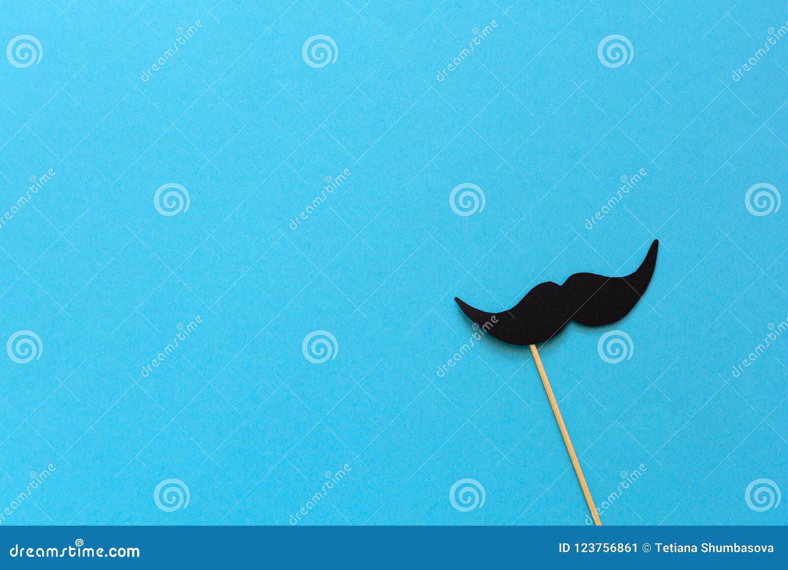 paper mustache on booth props on blue paper background. cut out style. movember concept.
