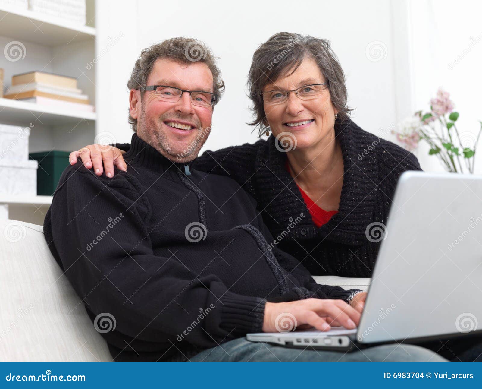 Par returnerar moget använda för bärbar dator. Sofa för mogen stående för closeupbärbar datorman sittande genom att använda kvinnan