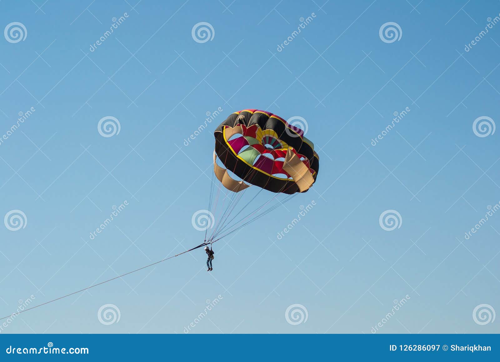 People On A Parachute Behind The Boat - Parasailing Stock 