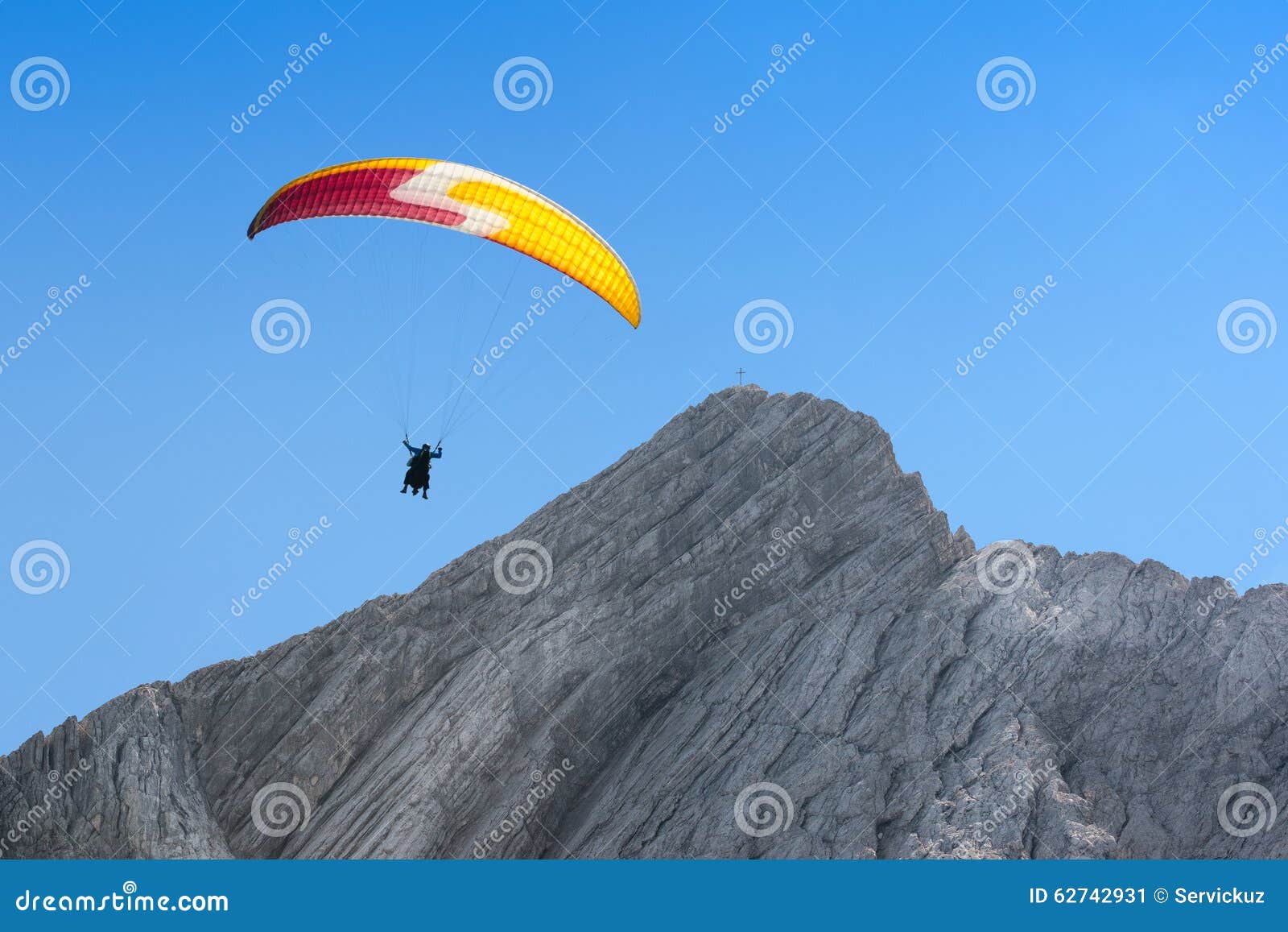 paraglider free soaring in cloudless sky over dolomites alpine m