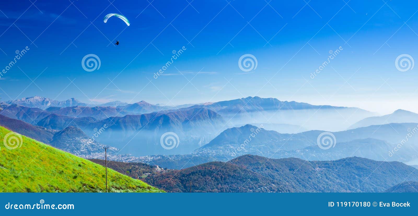 paraglider over the lugano city, san salvatore mountain and lugano lake seen from monte lema, canton ticino, switzerland