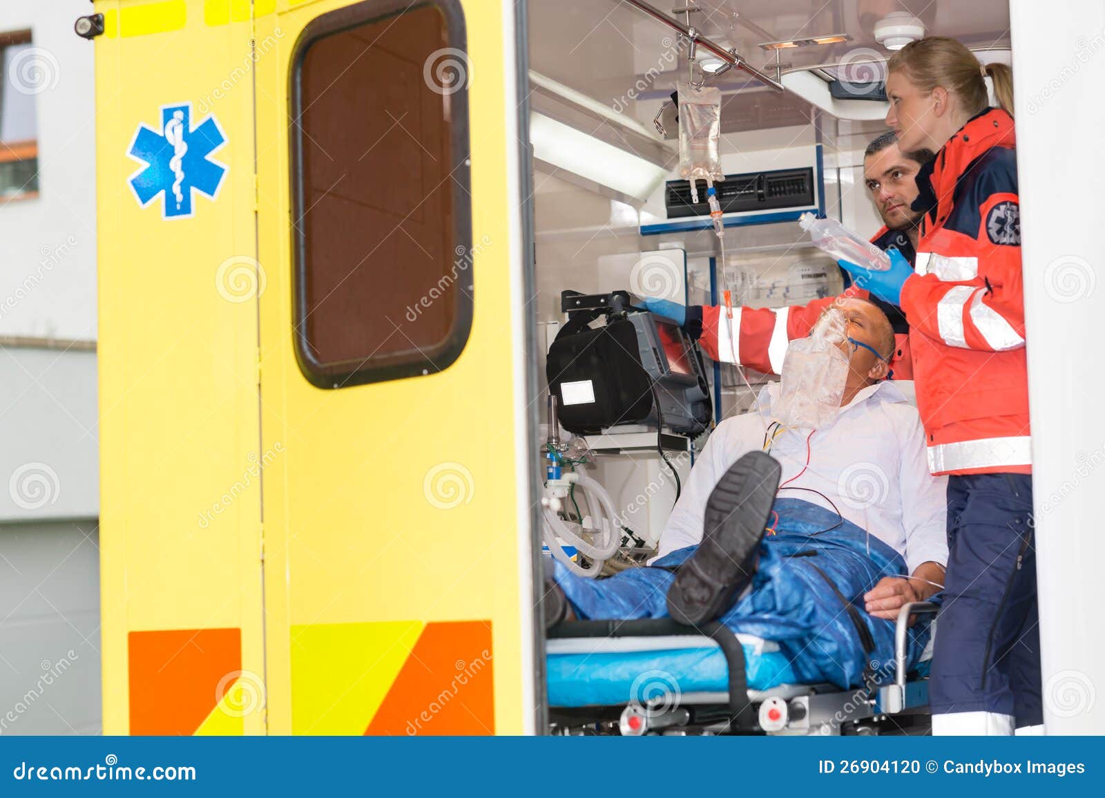 paramedics checking iv drip patient in ambulance